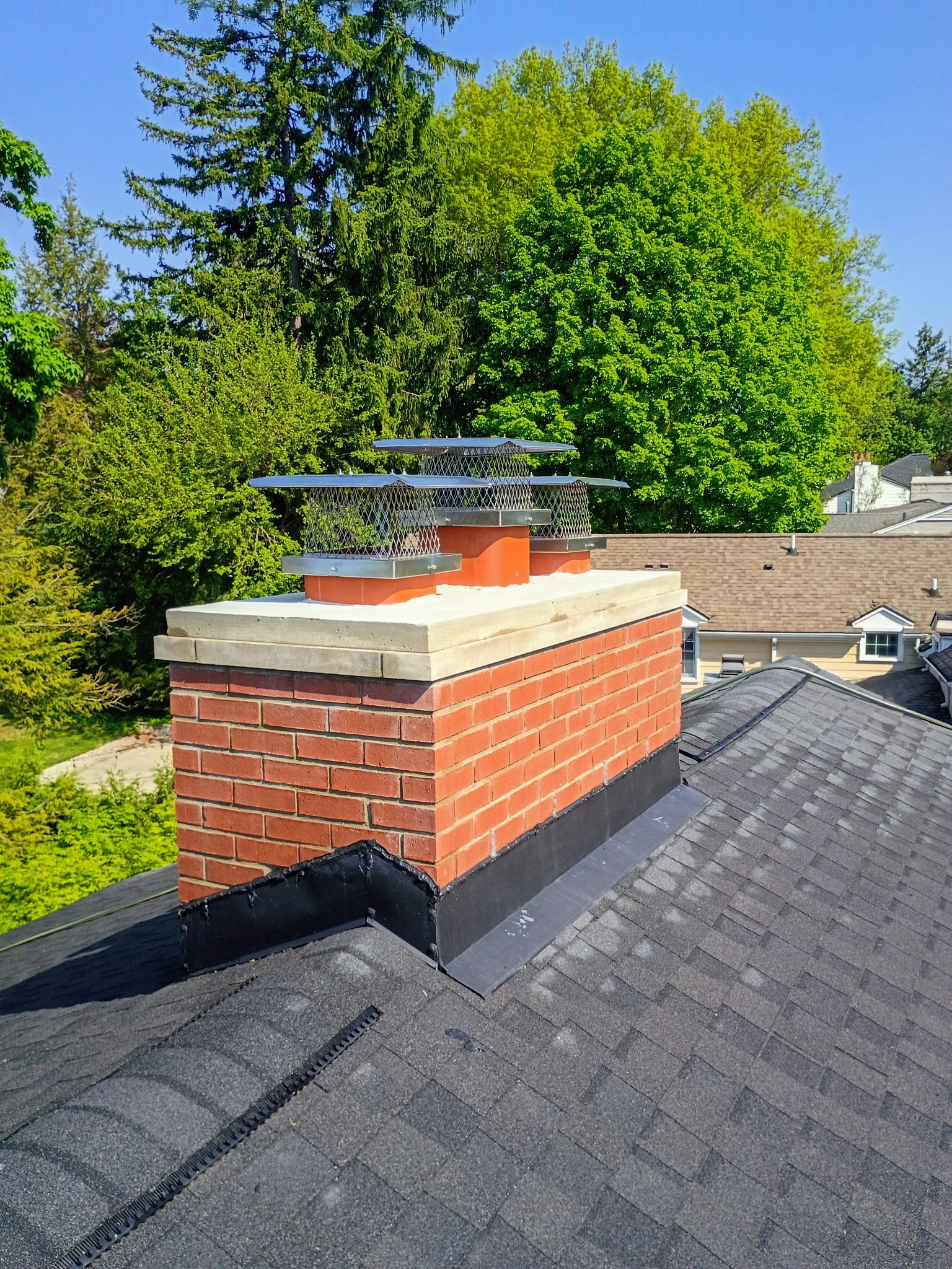 Completed chimney with stainless steel caps, blue sky