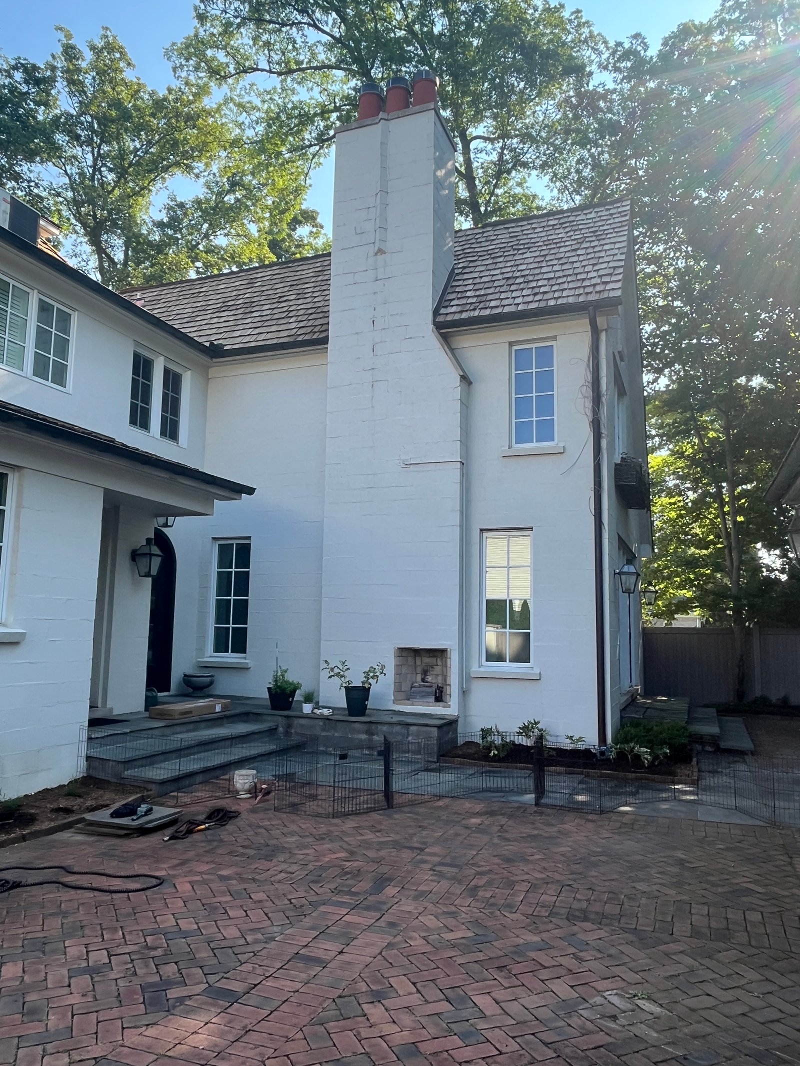 Chimney on luxury home with brick driveway